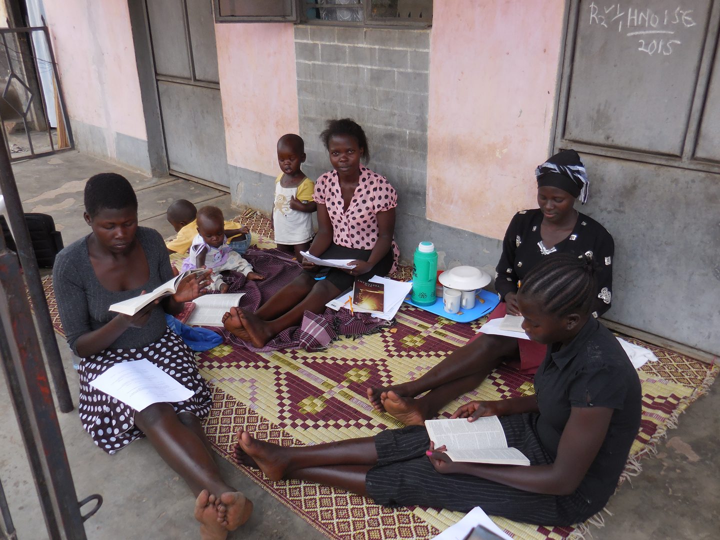 Young women studying with workbooks on a mat